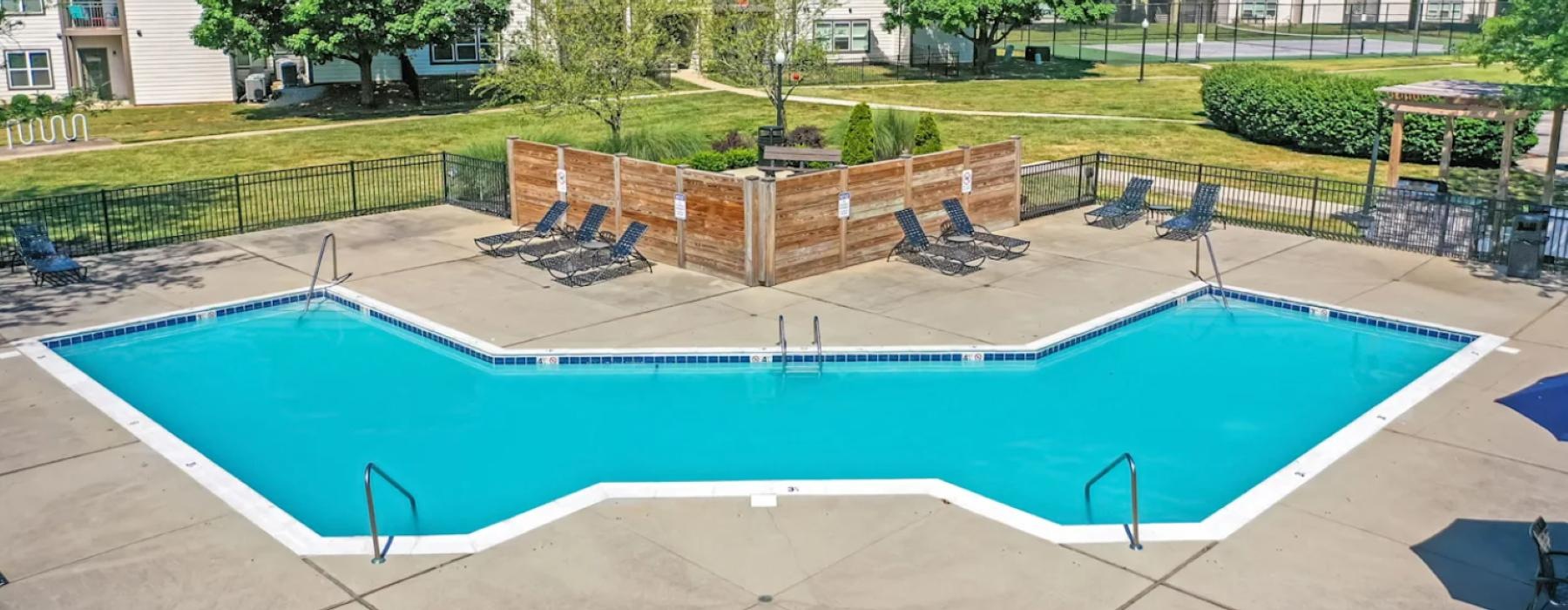 a swimming pool with chairs around it