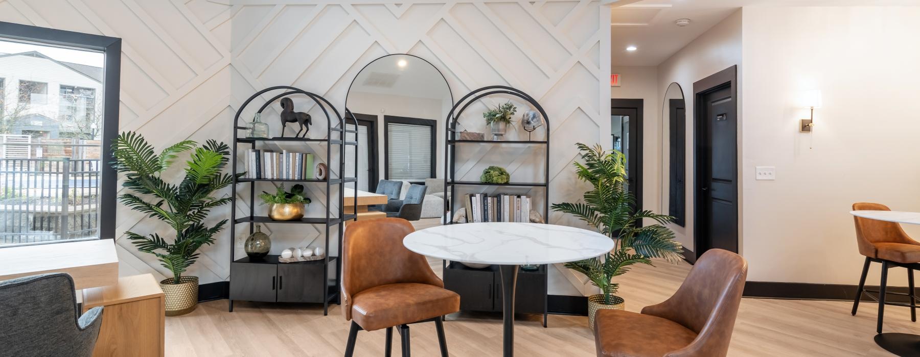 a room with a table chairs and a shelf with plants