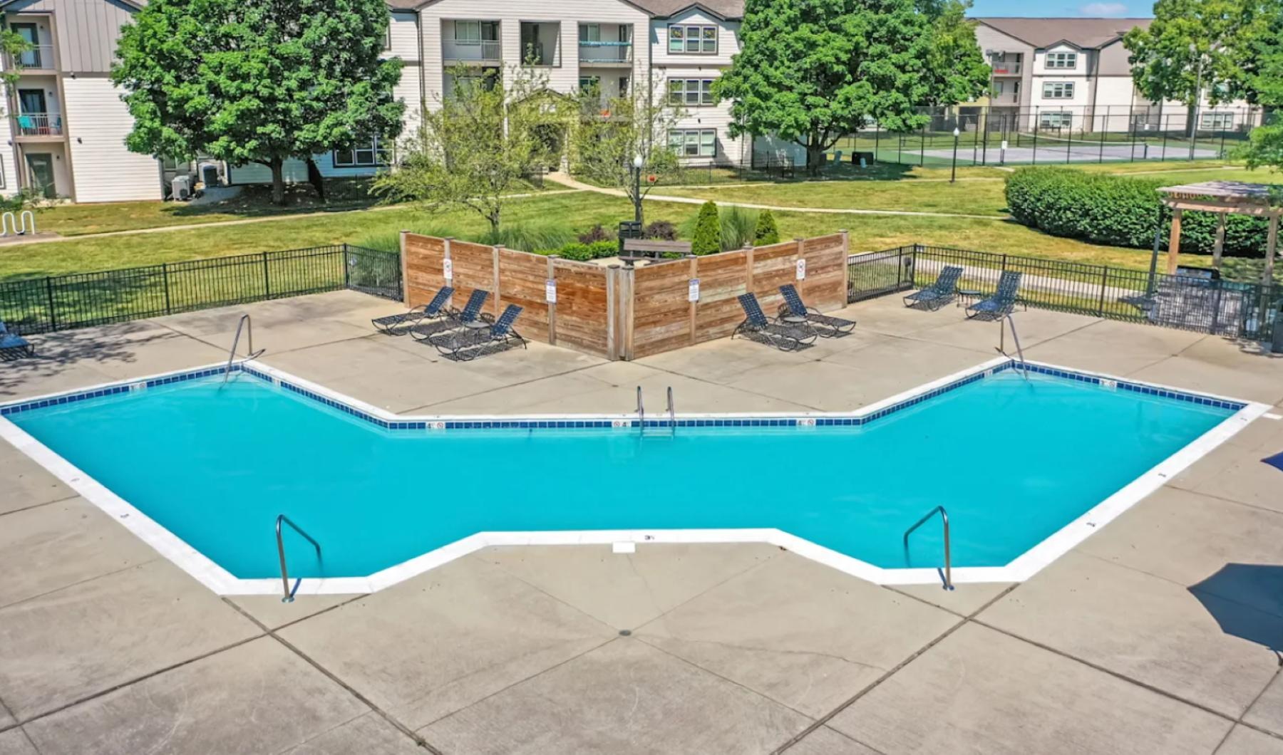 a swimming pool with chairs around it
